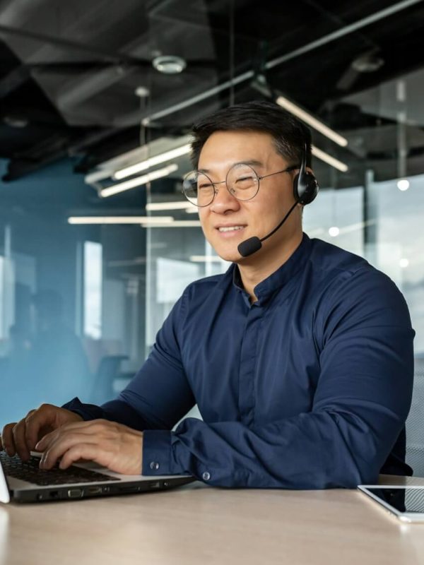happy-and-smiling-worker-with-headset-for-video-call-asian-tech-support-man-talking-to-online.jpg